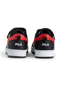 Mustat ja punaiset urheilukengät, joissa on teksturoitu nahkapinta, valkoinen välipohja ja tarranauha. Ominaisuuksiin kuuluu Fila-logo valkoisena kantapäässä.