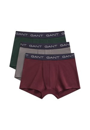 Tre paia di boxer da uomo in bordeaux, grigio e verde scuro con fasce nere marchiate con "GANT" in lettere bianche.