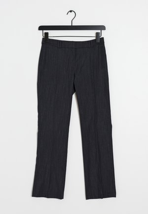 Pantalones de rayas en gris oscuro con corte recto, presillas para cinturón y bolsillos laterales, colgados de una percha negra sobre un fondo blanco.