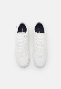 Pair of white low-top sneakers with laces and side zippers, viewed from above on a plain white background.
