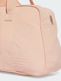 Pink duffel bag with a smooth texture, featuring a zippered closure and an embossed logo. Includes sturdy top straps and accent stitching.