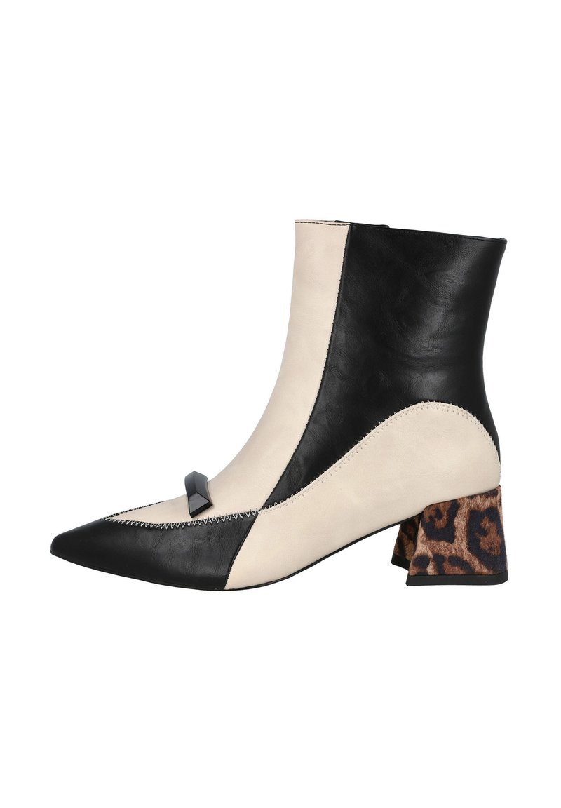 Botín de cuero con un diseño en negro y beige, punta afilada, tacón de bloque texturizado en contraste con un patrón de leopardo y accesorios decorativos.