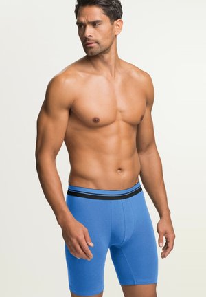 Blaue Boxershorts mit einem schwarz gestreiften elastischen Bund. Hergestellt aus weichem Stoff mit einer enganliegenden Passform, die bis zur Mitte des Oberschenkels reicht.