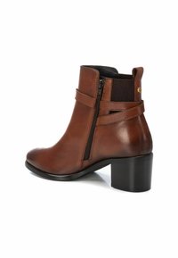 Botas de cuero marrón hasta el tobillo con cierre de cremallera, punta redonda y un robusto tacón cuadrado negro. Presentan paneles laterales elásticos y detalles de costura.