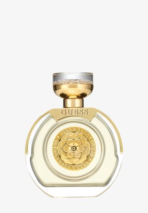 Runde, klare Parfümflasche mit goldenem Rand, einem goldenen Blumenemblem mit der Aufschrift "Guess Bella Vita" und einem goldenen sowie transparenten Deckel.