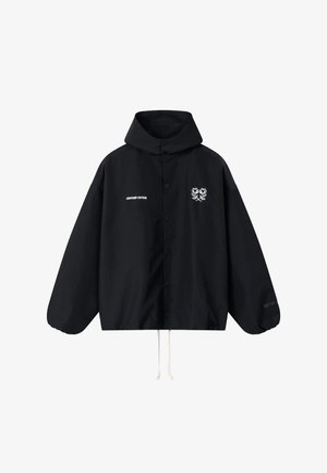 Fekete kapucnis dzseki elöl gombokkal, fehér húzózsinórokkal, bal mellrészen "ANOTHER COTTON" felirattal, jobb mellrészen két fehér virágos logóval.