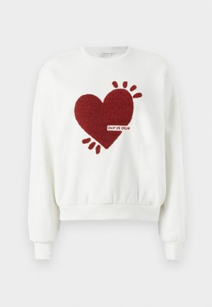 Valkoinen huppari, jossa on teksturoitu punainen sydäntoteutus ja koristeellisia yksityiskohtia. Ominaisuuksiin kuuluu pyöreä kaula-aukko ja ribbauskädet, sekä "Coup de Coeur" -merkintä.