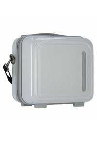 Valigia rigida argento con texture liscia, dotata di maniglia laterale e sottili dettagli lineari. Chiusura con zip e logo del marchio visibile.