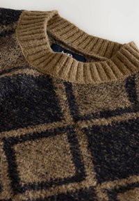 Maglione marrone a maglia con colletto a coste e motivo a quadri. La trama è morbida e pelosa, con quadrati scuri su uno sfondo più chiaro.