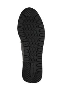 Semelle de chaussure en caoutchouc noir avec une surface texturée, présentant des motifs de grip arrondis et un profil de crampon varié pour une meilleure traction. Logo de la marque en relief.