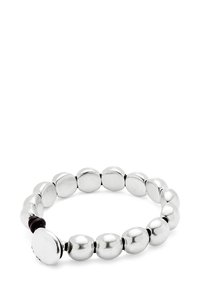 Pulsera de cuentas de plata con cuentas metálicas redondas, suaves y pulidas, y un pequeño acento oscuro en el cierre. Diseño flexible y circular.