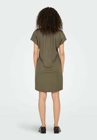 Olivengrünes Kleid mit lockerer Passform, kurzen Ärmeln und abgerundetem Saum. Aus weichem Stoff gefertigt, zeichnet sich durch ein einfaches Design aus.