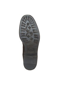 Semelle de chaussure en caoutchouc noir avec un motif de bande de roulement texturé présentant des formes de losanges et de croix entrelacées pour une meilleure adhérence. Marque estampillée visible.
