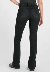 Zwarte flared jeans met een middelhoge taille, achterzakken en een soepele, licht gestructureerde denim stof. Zichtbare stiksels.