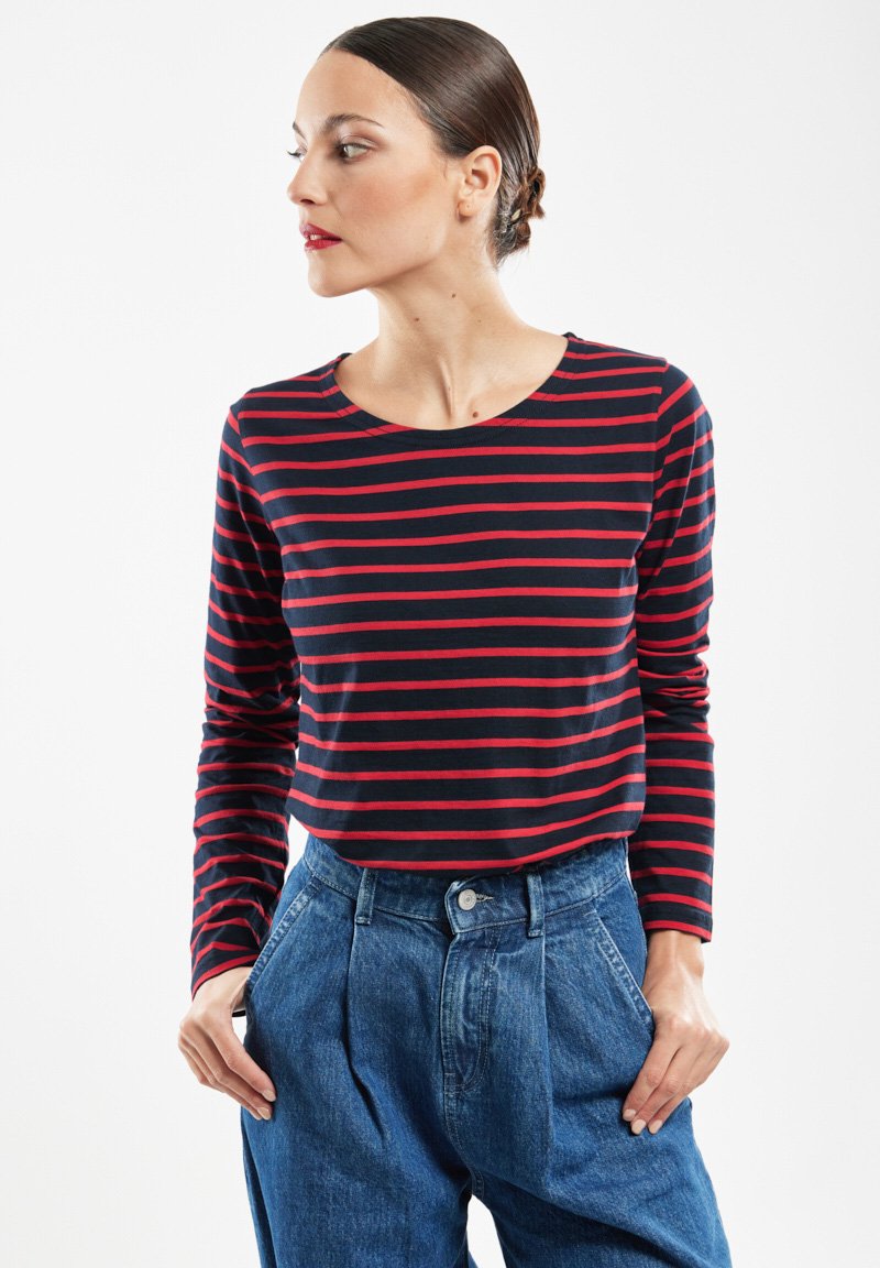 Langærmet top med marineblå og røde vandrette striber, rund halsudskæring og blødt stof. Sammen med højtaljede denimbukser.