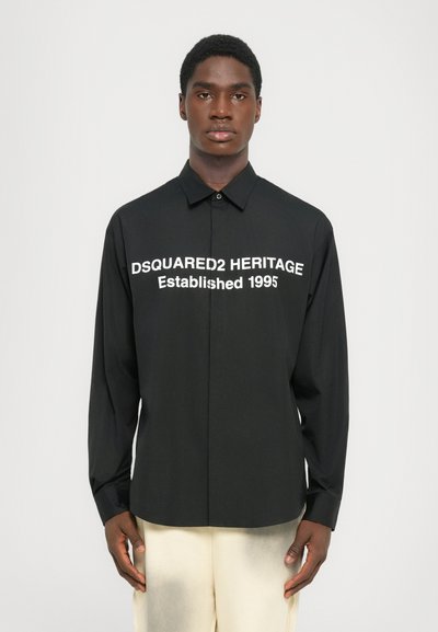 Zwarte langemouwen shirt met witte opdruk: "DSQUARED2 HERITAGE Opgericht 1995." Knoopsluiting met een klassieke kraag. Glad textiel.