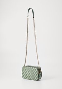 Borsa a tracolla verde a scacchi con tracolla a catena, dotata di chiusura con zip, superficie testurizzata e dettagli in hardware a contrasto.