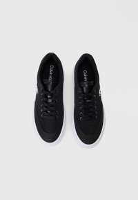 Μαύρα sneakers με λείο συνθετικό άνω μέρος, σχέδιο με κορδόνια και λευκή καουτσούκ σόλα. Έχει ένα μικρό λογότυπο στη πλευρά και επενδεδυμένο κολάρο.