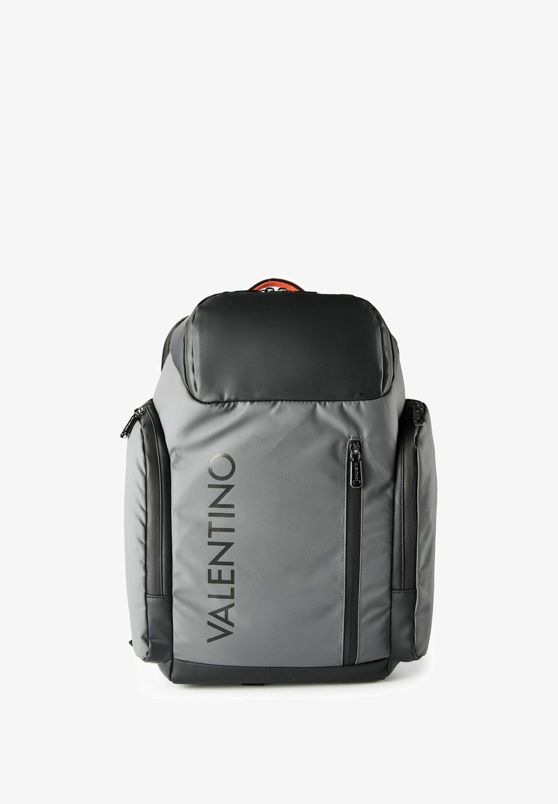 Sac à dos Valentino gris et noir avec plusieurs compartiments zippés et nom de la marque imprimé verticalement à l'avant.