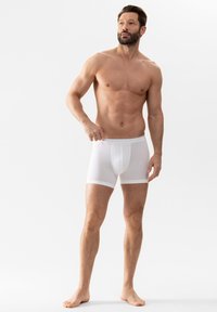 Witte boxershorts van zacht, rekbaar materiaal met een gladde tailleband, voorzien van een gecentreerde voorkantnaad en korte benen.