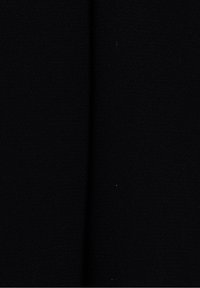 Vue rapprochée d'un tissu noir foncé avec une légère couture verticale descendant au centre.