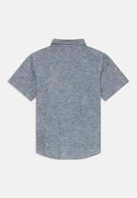 Šviesiai mėlynas trumpų rankovių marškinėliai iš tekstūruotos medžiagos. Su apykakle ir siūle nugaroje. Tiesus apatinis kraštas su apvalintais kraštais.