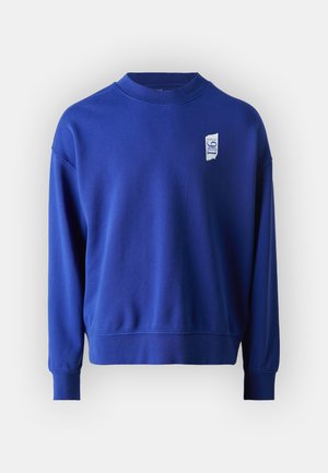 Sinine ümmarguse kaelusega dressipluus, mis on valmistatud pehmest puuvillast. Rinnal on valge logo aplikaat. Pikad varrukad ja soonikkoes mansetid. Tavaline lõige.