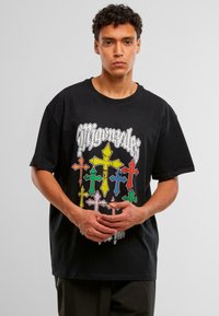Zwarte katoenen t-shirt met multicolore kruisgraphics en een gedurfd logo. Korte mouwen, ontspannen pasvorm en ronde hals.