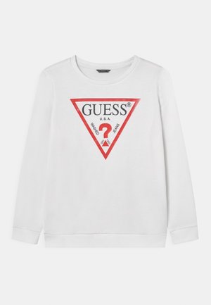 Hvid sweatshirt med lange ærmer, rund halsudskæring, med en rød trekantet logo med teksten "GUESS" og "WASHED JEANS". Glat stoftekstur.