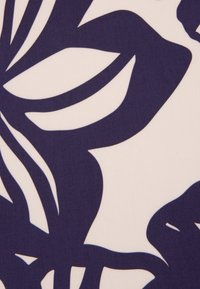 Tessuto a fantasia floreale con silhouette blu scuro su sfondo crema chiaro; texture liscia con forme fogliari audaci e grafiche.