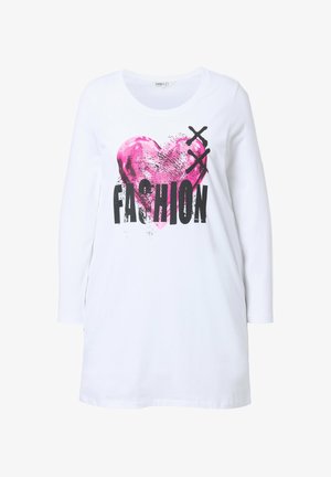 Chemise blanche à manches longues avec un graphique de cœur rose et du texte noir en gras indiquant "FASHION", avec une coupe décontractée et une texture douce.