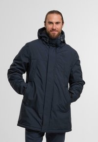 Giacca isolante blu navy con cappuccio, dotata di due tasche frontali, chiusura con zip e texture trapuntata nella zona del petto.