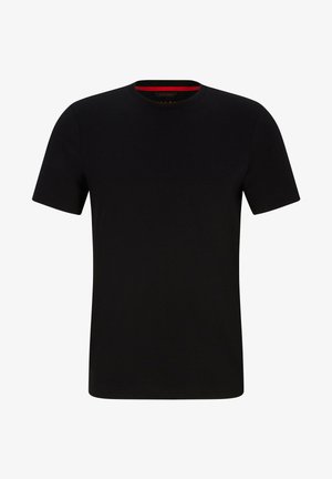 Czarna sportowa koszulka z krótkim rękawem, wykonana z gładkiego materiału. Połączona z czarnymi szortami i białymi sneakersami. Prosty, czysty design.