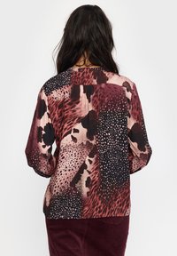 Langermet bluse med et blandet dyreprint i burgunder, beige og svarte toner; lett stoff med en glatt tekstur og løs passform.