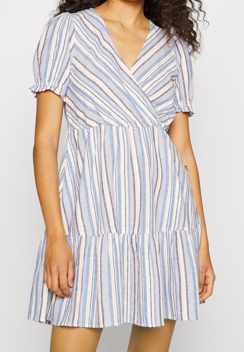 Robe rayée avec un style portefeuille, des manches courtes bouffantes et une jupe à volants. Couleurs : bleu clair, rose et blanc. Tissu texturé.