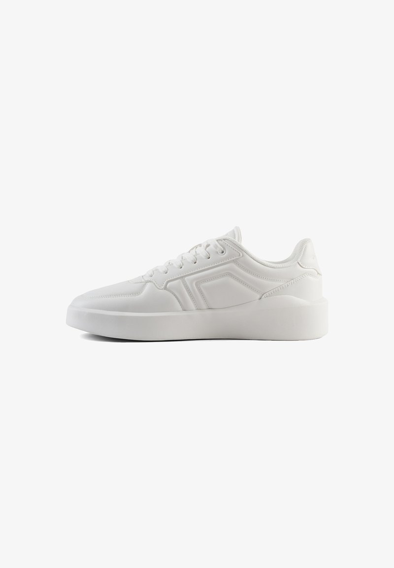 Zapatillas deportivas blancas con una parte superior sintética suave, diseño de cordones, suela acolchada y acentos geométricos a los lados.