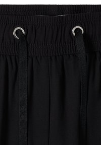 Ceinture élastique noire avec des fronces cousues et deux cordons noirs passés à travers des œillets métalliques argentés.