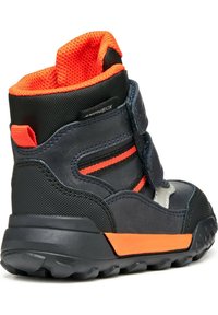 Botín negro y gris con detalles en naranja, suela de goma texturizada, dos correas de velcro y forro de malla en el collar para mayor comodidad.
