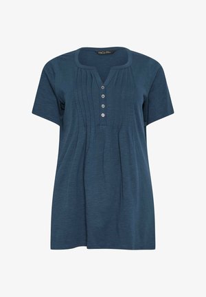 Blaues Kurzarmbluse mit rundem Ausschnitt mit Kerbe, vier Knöpfen vorne und vertikalen Falten im Brustbereich.