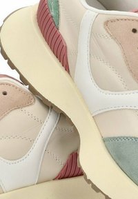 Zapatillas beige con acentos en blanco y tonos pastel, con una superficie texturizada, suela de goma y detalles cosidos. Soporte acolchado en el talón en color rosa.