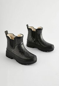 Bottines à paillettes noires avec doublure en cream moelleux, panneaux latéraux élastiques et semelle en caoutchouc noir texturé. Dotées d'une languette pour un enfilage facile.