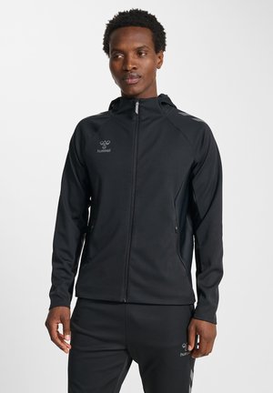 Giacca sportiva nera con cerniera frontale, cappuccio e dettagli riflettenti. Caratterizzata da tessuto liscio e tasche laterali per lo stoccaggio.