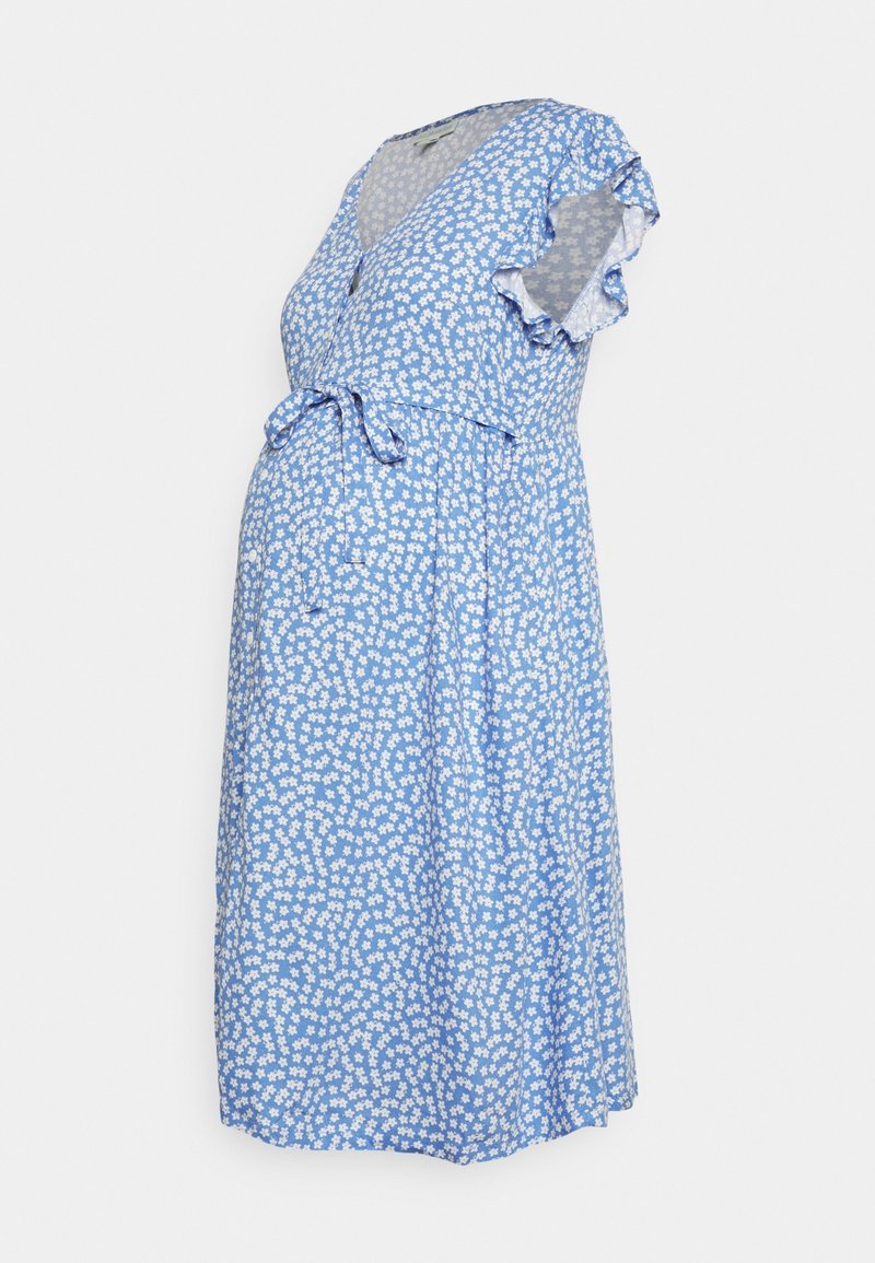Vestido floral azul con un diseño envolvente, cortas mangas rizadas y un detalle de lazo en la cintura. Presenta un patrón de margaritas blancas sobre un fondo azul claro.