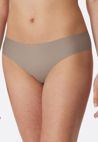 Beige seamless bikini briefs with a smooth texture and a low-rise cut. Features a simple design without visible seams or hardware accents.