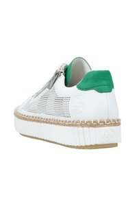 Baskets blanches perforées avec des accents en daim vert, semelle tressée beige et détail de fermeture éclair métallique. Texture lisse et forme arrondie.