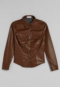 Camicia in finta pelle marrone con maniche lunghe, due tasche sul petto e chiusura a bottoni a pressione, caratterizzata da un taglio aderente e una finitura lucida.