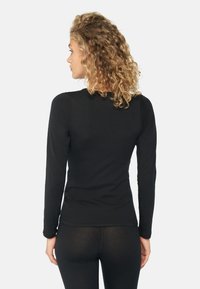 Zwarte langslijfshirt met een ronde hals en een getailleerde pasvorm, gemaakt van zachte, rekbare stof, met raglanmouwen en een gladde textuur.