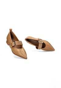 Zapatos de punta afilada de cuero suave con una amplia correa en el tobillo que presenta brillantes círculos plateados y un bajo tacón bloque.