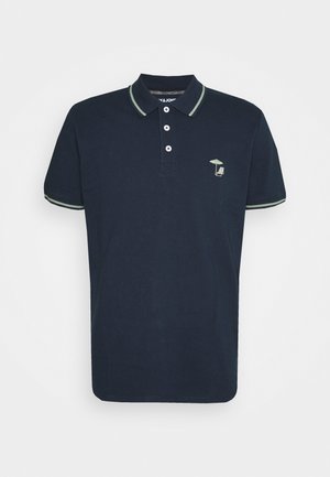 Mørkeblå polo med lysegrøn trim på krave og ærmer, tre knapper og lille paraply- og stolbroderi på venstre bryst.