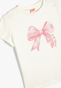 Hvid bomulds-T-shirt med et pink glimmer sløjfe grafik og teksten "DU ER VIDUNDERLIG" i pink, rund font. Korte ærmer.
